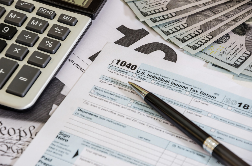Tax preparation documents, calculator, and financial records on a desk